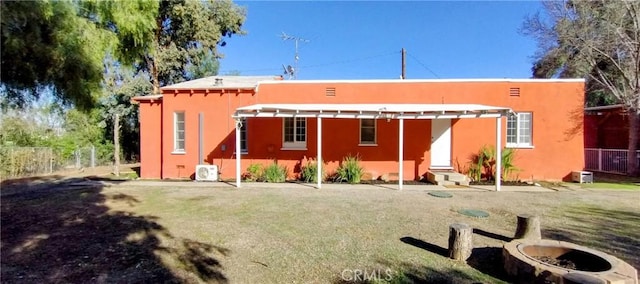 rear view of property featuring entry steps, fence, and stucco siding