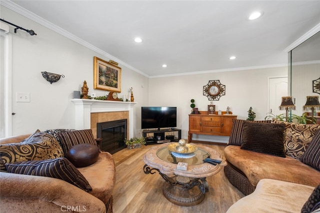 living area featuring recessed lighting, crown molding, a tiled fireplace, and wood finished floors