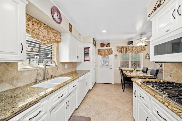 kitchen featuring white appliances, ceiling fan, white cabinets, and a sink