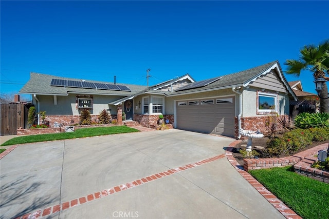 single story home featuring solar panels, stucco siding, concrete driveway, fence, and a garage