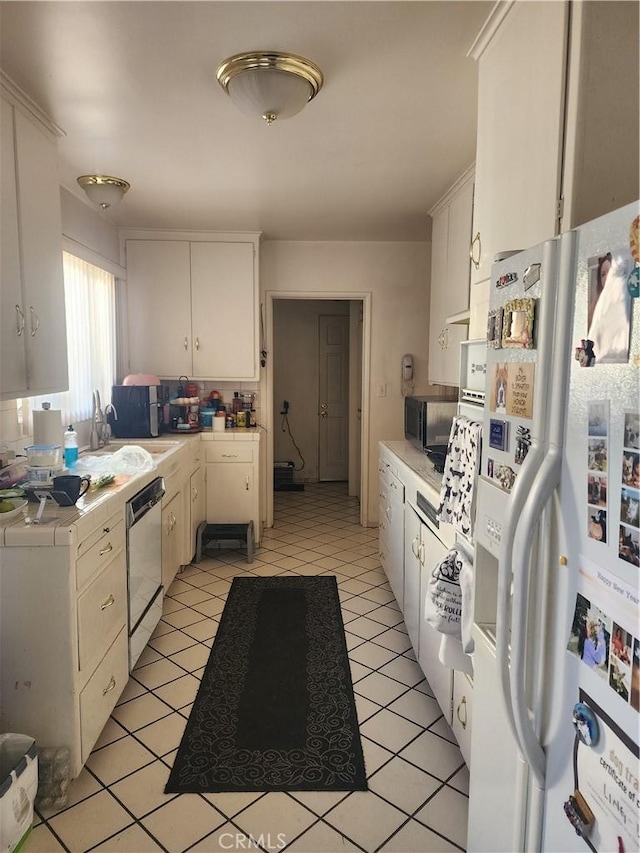 kitchen with white cabinetry, appliances with stainless steel finishes, sink, and light tile patterned floors