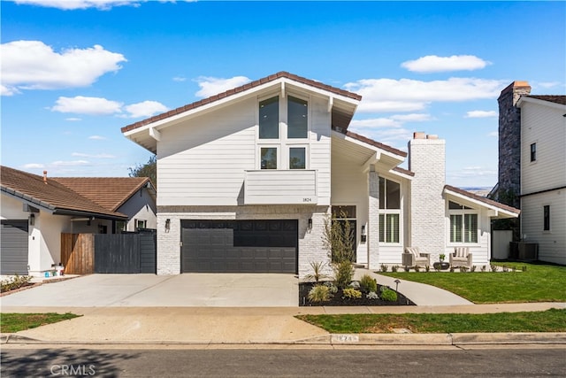 view of front of house featuring brick siding, central air condition unit, concrete driveway, fence, and a garage