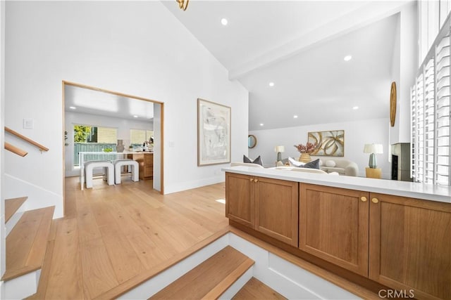 interior space featuring open floor plan, light countertops, light wood-type flooring, and brown cabinets