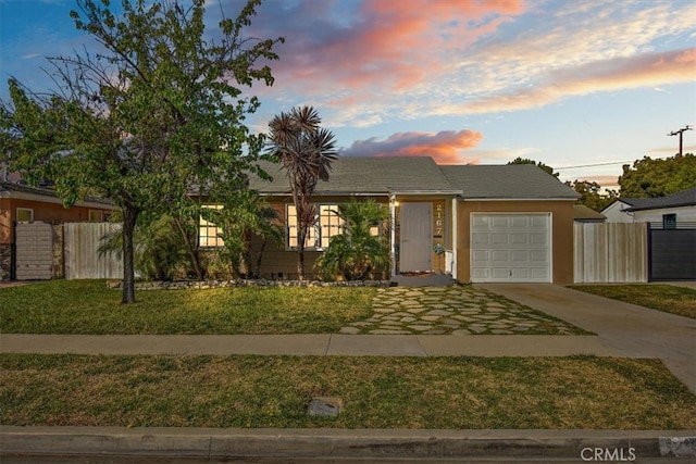 ranch-style home with concrete driveway, an attached garage, fence, and a front yard