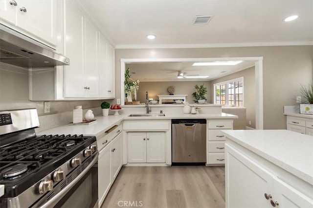 kitchen featuring stainless steel appliances, light countertops, visible vents, a sink, and under cabinet range hood