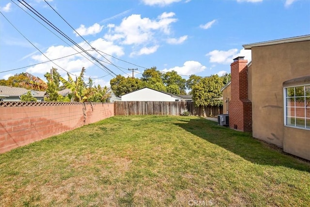 view of yard featuring a fenced backyard and central AC