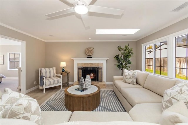 living room featuring visible vents, crown molding, baseboards, and a premium fireplace