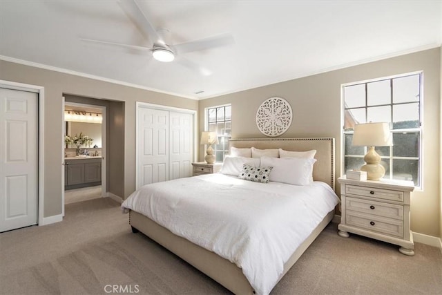 bedroom featuring baseboards, ornamental molding, connected bathroom, and light colored carpet