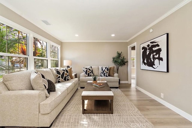 living area with visible vents, ornamental molding, light wood-style flooring, and baseboards