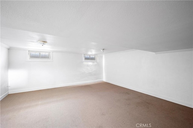 interior space with a textured ceiling, carpet floors, and baseboards
