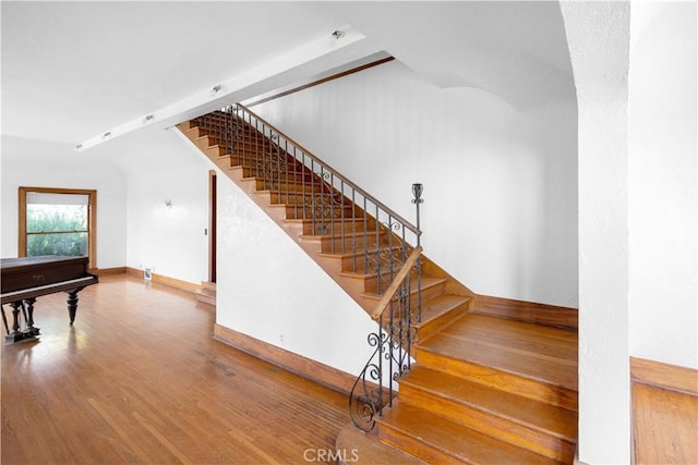 staircase with baseboards and wood finished floors
