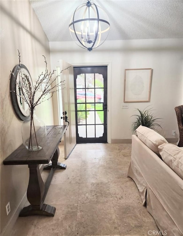 doorway featuring an inviting chandelier, baseboards, and a textured ceiling