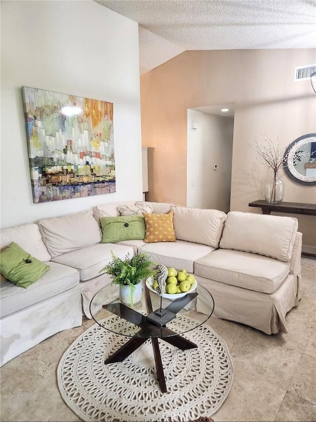 living room featuring visible vents, a textured ceiling, and vaulted ceiling