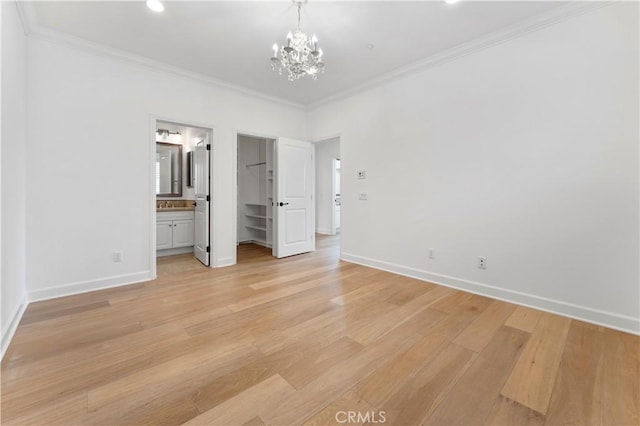 unfurnished bedroom featuring light wood-style floors, baseboards, ornamental molding, and a notable chandelier