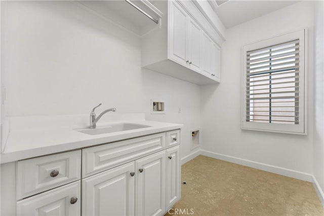 clothes washing area with washer hookup, a sink, cabinet space, and baseboards