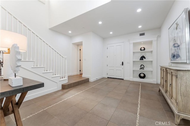 entryway featuring light tile patterned floors, baseboards, visible vents, stairs, and recessed lighting