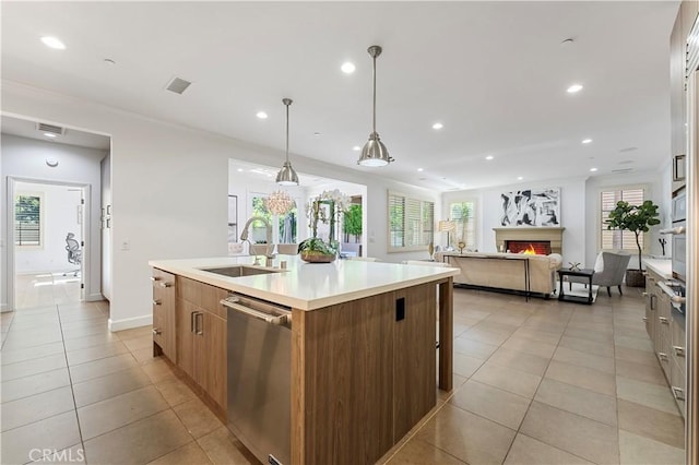 kitchen featuring dishwasher, a warm lit fireplace, a sink, and recessed lighting