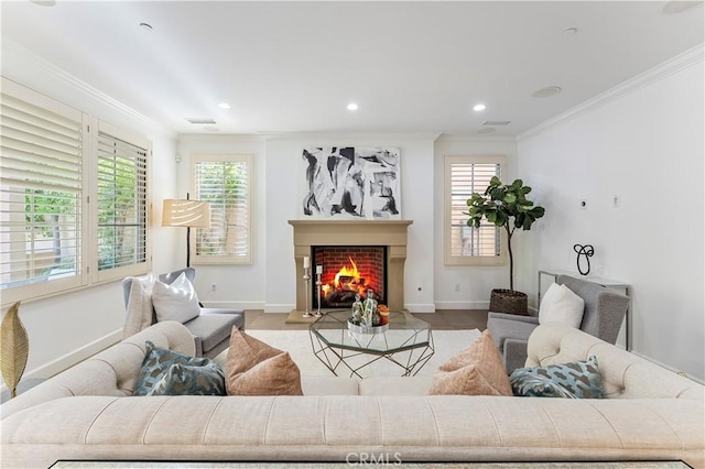 living room featuring visible vents, baseboards, a fireplace with flush hearth, crown molding, and recessed lighting