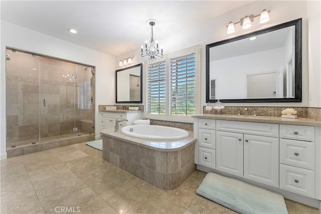 full bathroom with vanity, a shower stall, a bath, and a notable chandelier