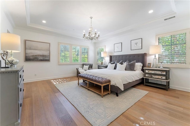 bedroom featuring a tray ceiling, light wood-style floors, multiple windows, and crown molding