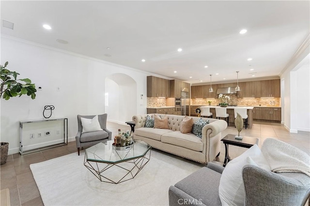 living room featuring arched walkways, light tile patterned floors, recessed lighting, and crown molding