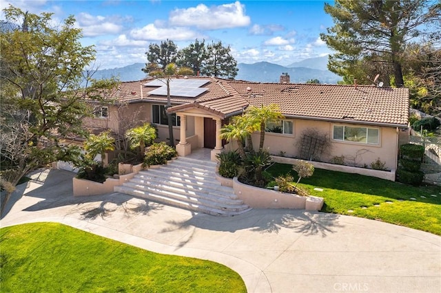 view of front of home featuring solar panels and a mountain view