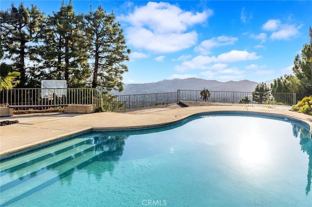 view of pool with a mountain view and a patio