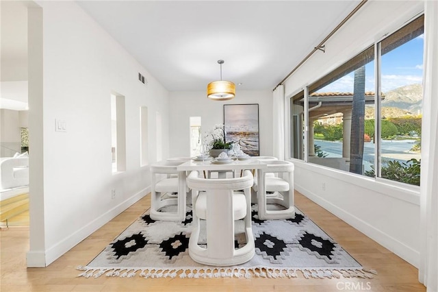 dining space featuring a mountain view and light hardwood / wood-style floors