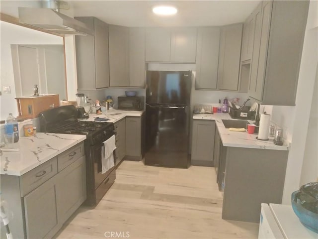 kitchen featuring gray cabinetry, refrigerator, gas stove, and sink