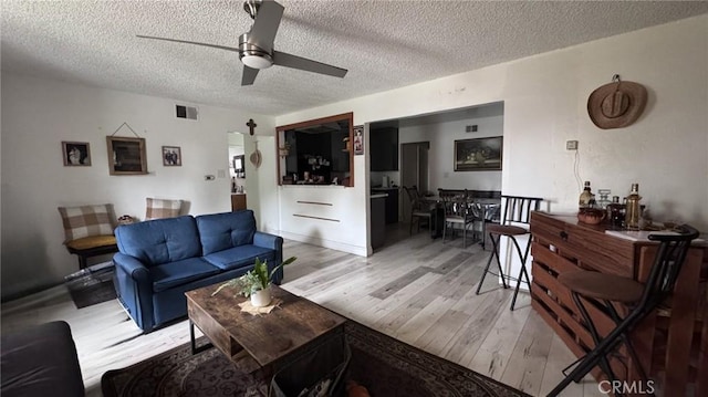 10813 State St, Lynwood, CA 90262 - living area with light wood-type flooring, a textured ceiling, and ceiling fan