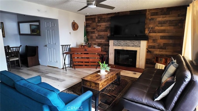 10813 State St, Lynwood, CA 90262 - living room with ceiling fan, wood finished floors, a textured ceiling, and a stone fireplace