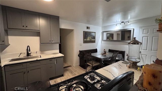 10813 State St, Lynwood, CA 90262 - kitchen featuring a sink, light countertops, gray cabinetry, and light wood finished floors