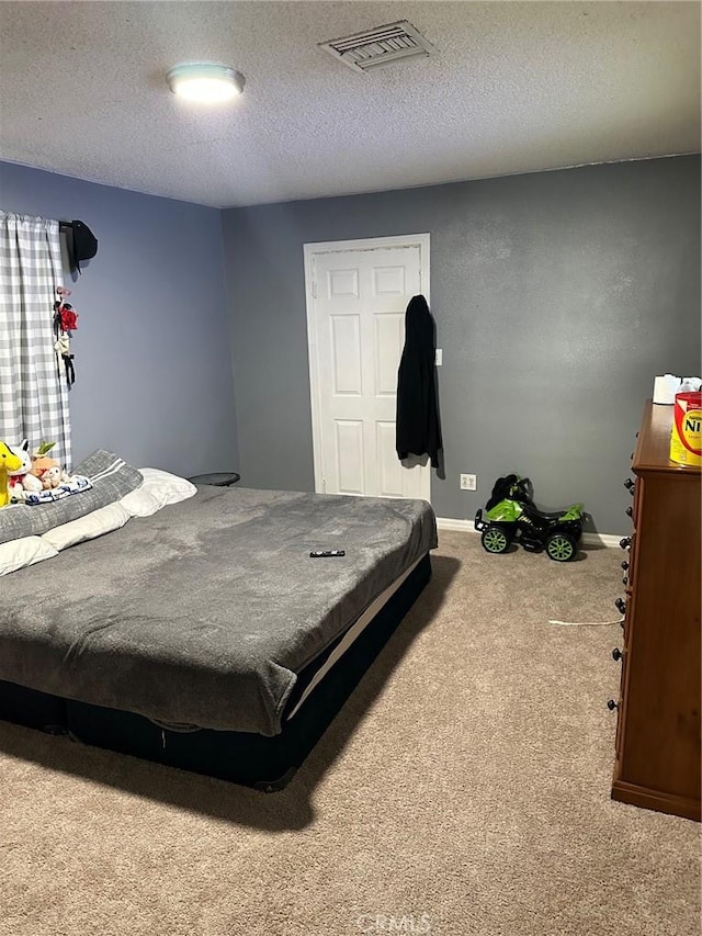 bedroom featuring carpet floors and a textured ceiling