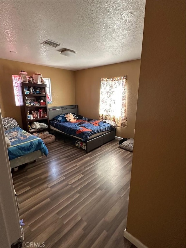 bedroom with wood-type flooring and a textured ceiling