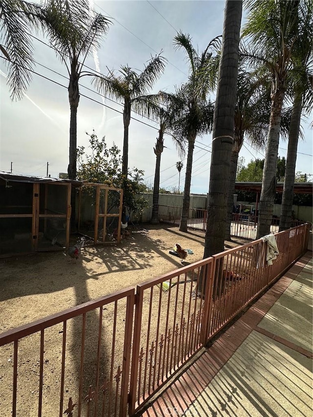 wooden terrace with an outdoor structure and fence