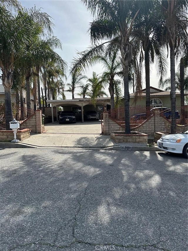 view of front of home featuring an attached carport, fence, and driveway