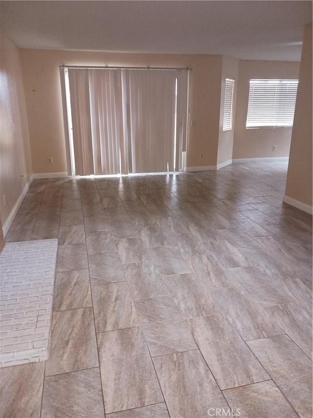 unfurnished room featuring baseboards