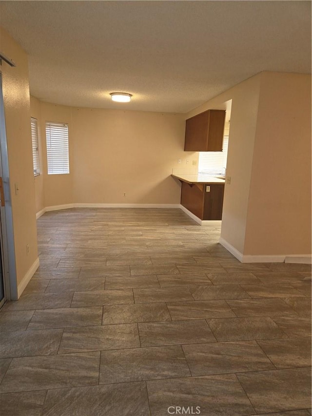 interior space featuring a textured ceiling, wood finished floors, and baseboards