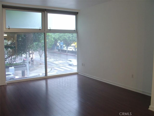empty room with baseboards and wood finished floors