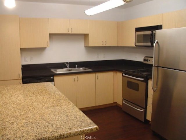 kitchen featuring light brown cabinets, stainless steel appliances, dark wood-style floors, and a sink