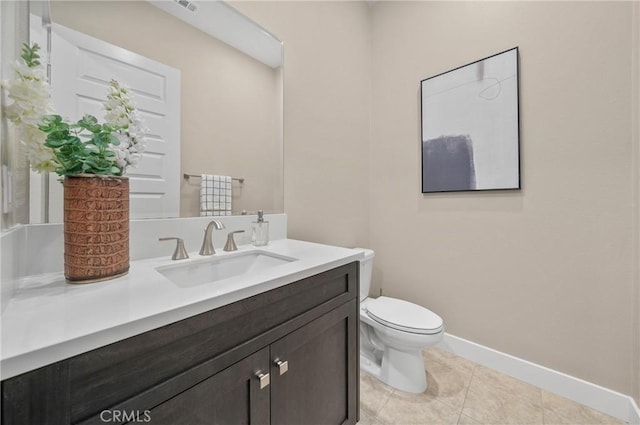 bathroom featuring toilet, tile patterned floors, baseboards, and vanity