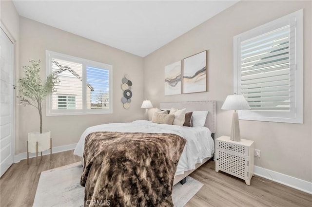 bedroom with baseboards and light wood-style floors