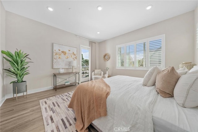 bedroom featuring light wood-type flooring, access to outside, baseboards, and recessed lighting