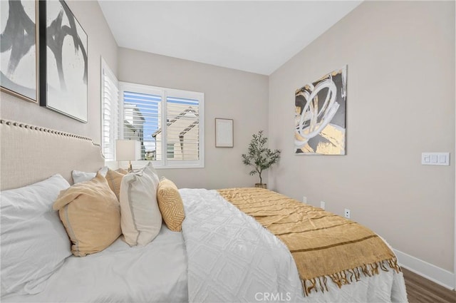 bedroom with wood finished floors and baseboards