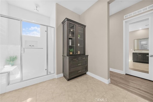 interior space featuring light tile patterned floors, baseboards, and visible vents