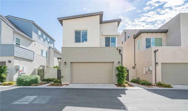 multi unit property featuring a garage and stucco siding