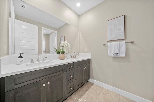 full bath featuring double vanity, visible vents, baseboards, and a sink