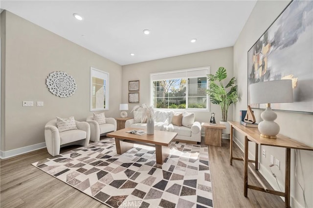 living area with baseboards, wood finished floors, and recessed lighting