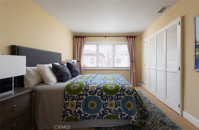 bedroom featuring light carpet, a closet, visible vents, and baseboards