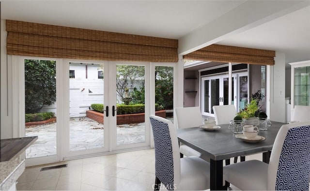 sunroom featuring french doors, plenty of natural light, and visible vents